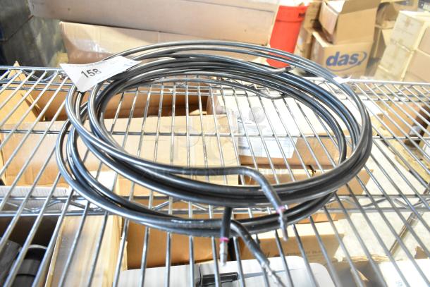 Coiled round burner element wire, black, auction tag number 158, on metal shelf, new condition.