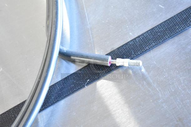 Metallic round burner with a single connector and hose. Appears to be in good condition. No visible brand or labels.