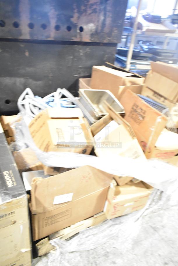 Assorted items including stainless steel bins, metal racks, and sealed packages on a pallet, condition varies.