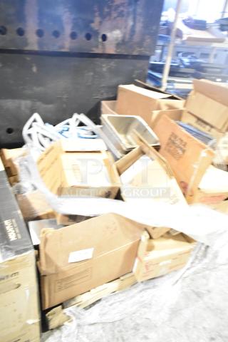 Assorted items including stainless steel bins, metal racks, and sealed packages on a pallet, condition varies.
