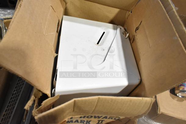 Cardboard box containing various items, including a white metal object with a slot. Box is slightly worn. Set of 25 mixed items.