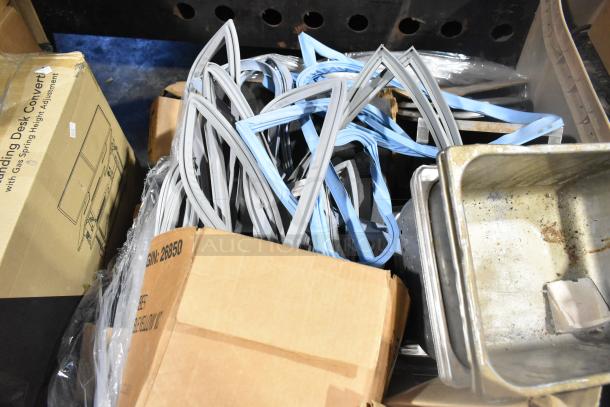 Various items including blue and gray seals, stainless steel drop-in bins, and metal racks in cardboard boxes. Used condition.