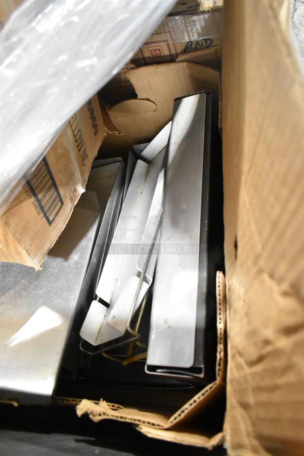 Box containing various stainless steel drop-in bins and metal racks, in good condition. Includes mix of 25 items.