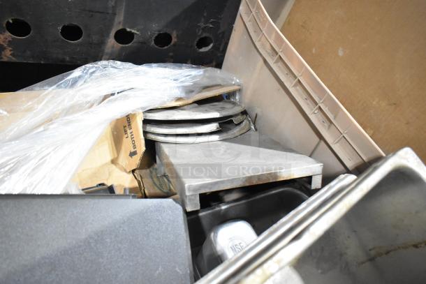 Alt text: "Assorted lot with metal racks, stainless steel bins, and various seals. Includes packaging materials. 25 items total."