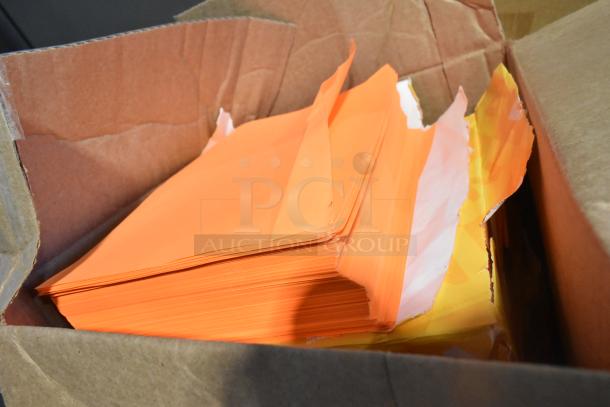 Box of orange paper sheets, partially opened, showing vibrant color and clean edges.