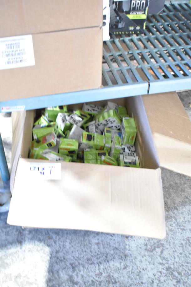 Box containing 98 new scratch and dent Trodat ink pads in black, blue, green, and red.