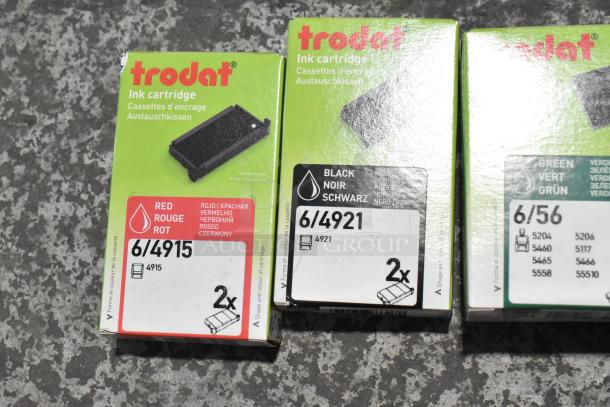 Trodat ink pads in original packaging, colors include red, black, and green. Labels indicate model numbers 6/4915, 6/4921, 6/56.