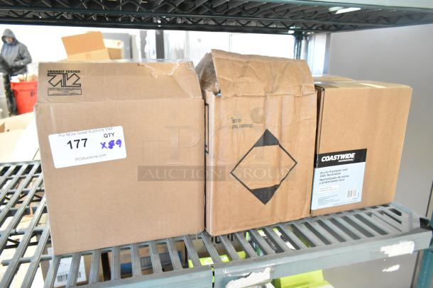 Boxes of Coastwide dry air freshener and Diversey cleaners on shelf; labeled "9x your bid," slight damage visible.