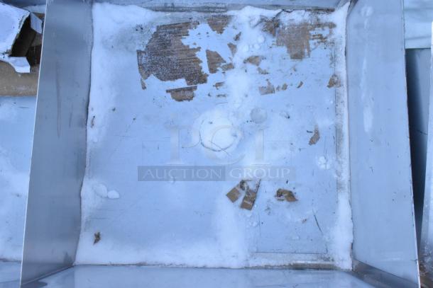 Brand new Regency 2 Bay Sink; shows scratch and dent condition with visible snow and debris.