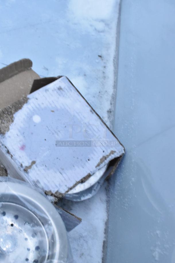 Regency 2 Bay Sink, new with scratch and dent defects, visible in packaging. Stainless steel construction.