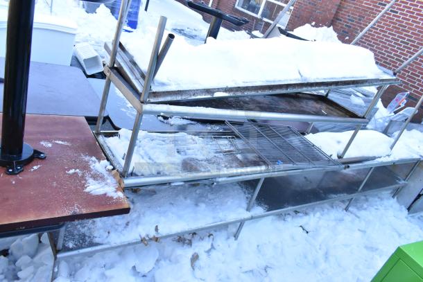 Four metal overshelves outdoors in snowy condition, various sizes and designs, used state, suitable for storage.