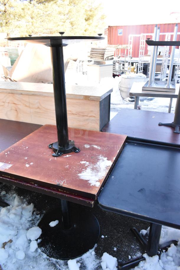 Three dining height tables with sturdy metal bases, showing signs of wear, ideal for commercial use or repurposing.