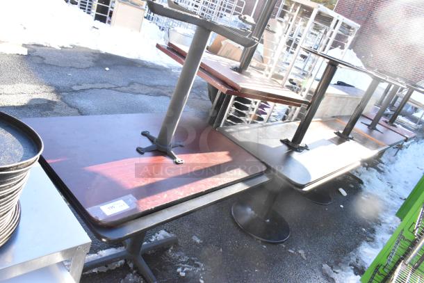 Eight dining height tables, wooden tops, metal bases, used condition, stacked outdoors, sale tag shows "195."