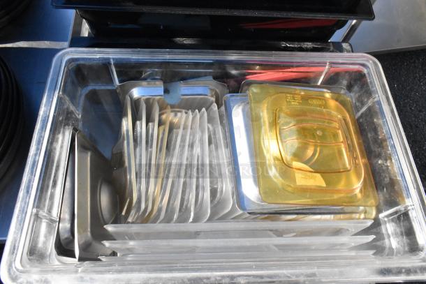 3 tier cart with commercial casters, containing a colander, numerous poly drop-in bins, and assorted kitchenware.