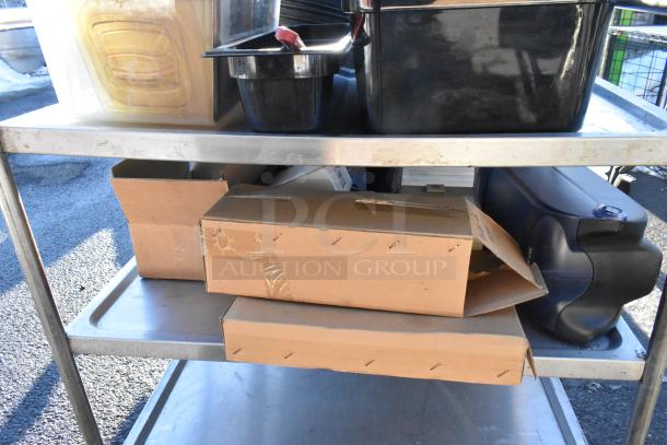 3-tier metal cart on commercial casters with contents including poly bins and a colander. Sturdy, used condition.