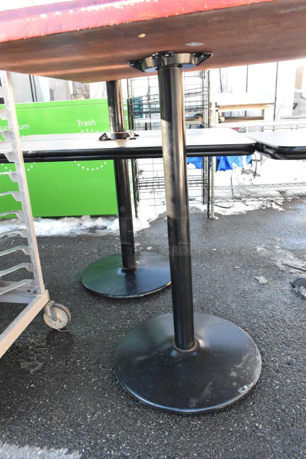 Two bar height tables with sturdy black metal bases and wood tops, in good condition. Ideal for restaurants or bars.