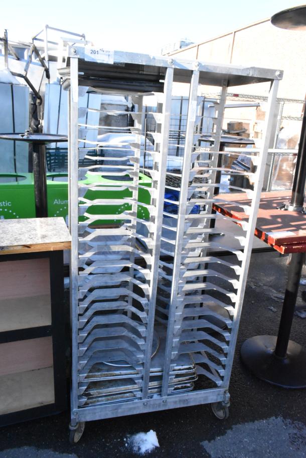 Metal pan transport rack with commercial casters, holds multiple trays, sturdy metal construction, used condition.
