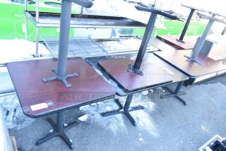 Six dining-height square tables, dark wood tops, metal pedestal bases, fair condition, label "203" visible on one.