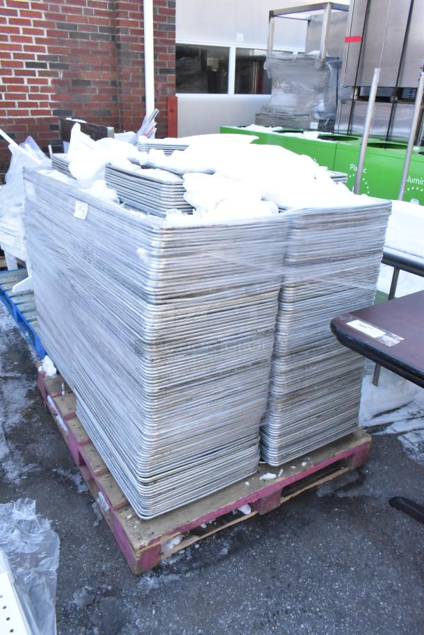Stack of 392 metal baking pans, full and half size, shrink-wrapped on pallets, suitable for commercial use.