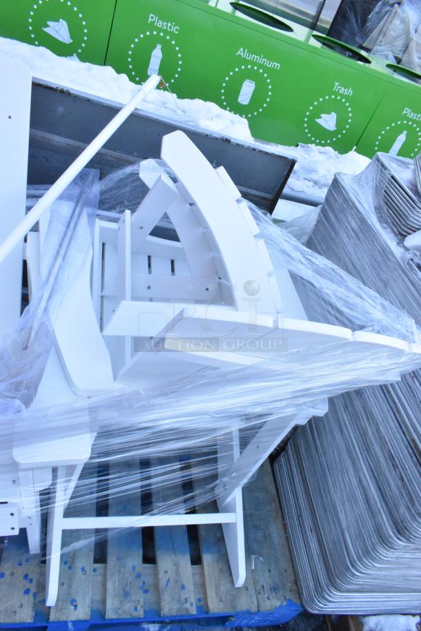 White wooden Adirondack chairs stacked and wrapped, part of an auction lot including an end table and mixing paddles.