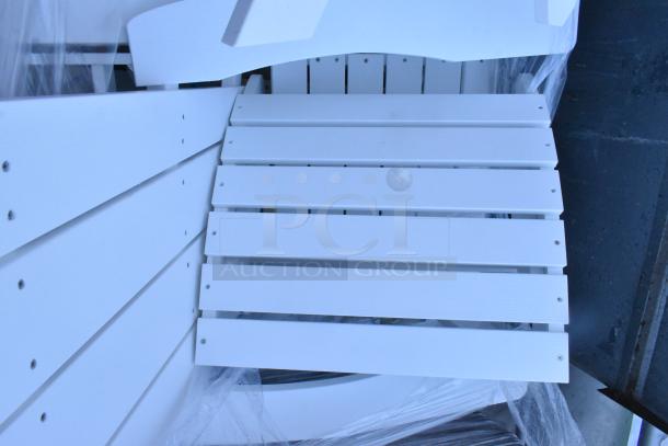 Assorted white slatted outdoor furniture, including chairs and end table, in new or like-new condition, secured with protective wrapping.