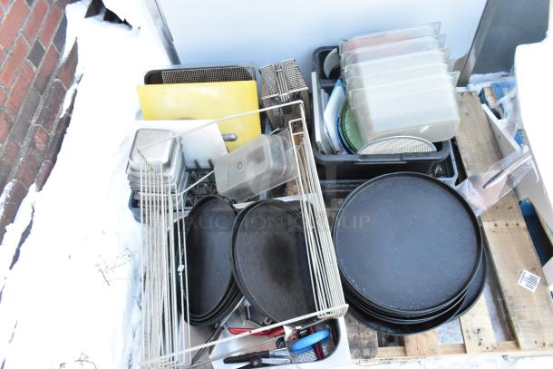 Pallet lot with serving trays, poly drop-in bins, fry basket, and utensils. Items appear used. Includes storage crates.