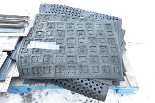 14 various floor mats with geometric patterns and perforations, stacked on a pallet. Some wear visible.