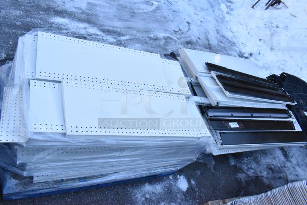 Pallet lot of various shelves and items, including perforated white metal panels. Items appear in used condition.