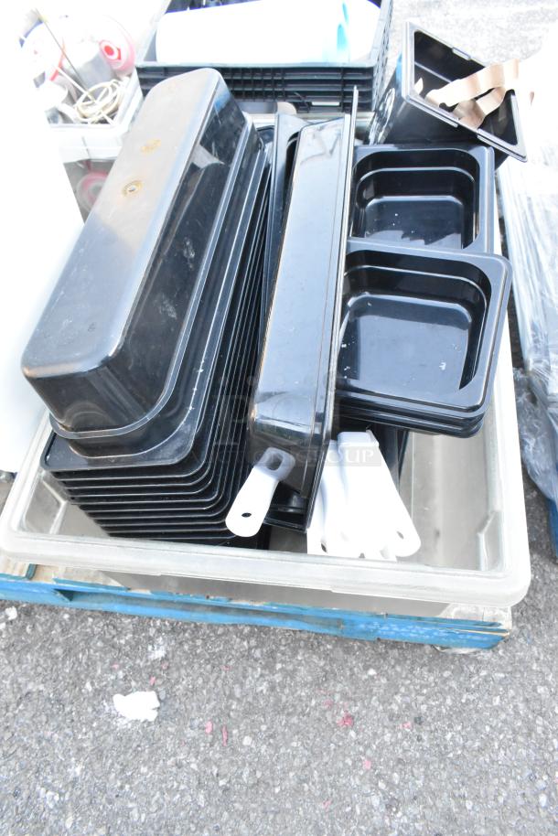 Pallet of various kitchen items including black ingredient bin, poly bins, serving spoons, and spatulas, in good condition.
