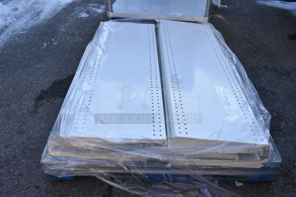 Pallet of white metal shelves, wrapped in plastic. Shelves feature perforations for adjustable mounting, showing a label with SKU number.