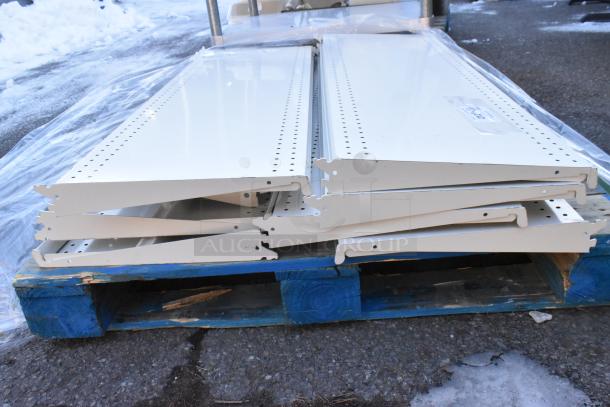 Pallet of metal shelves stacked on blue pallet, featuring perforated edges, in good condition, wrapped in plastic.