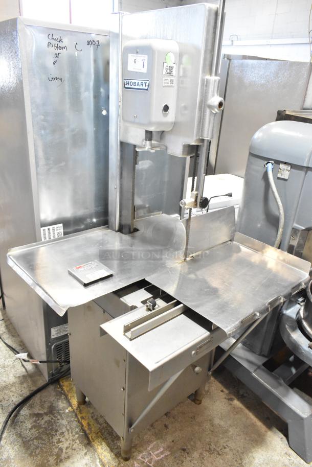 Hobart 5614 commercial meat saw, floor style, 200-230V, 3 phase; features stainless steel construction, safety labels visible.