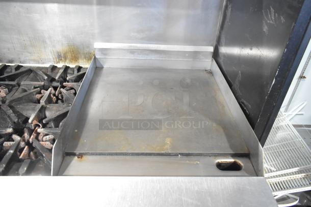 Garland commercial gas range; 6 burners, flat top, 2 ovens, over shelf, backsplash; used condition.