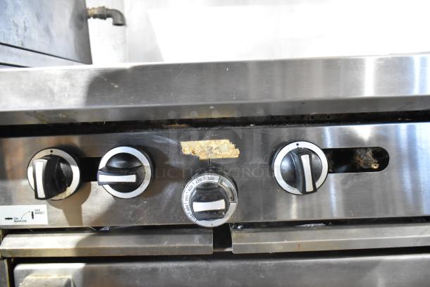 Garland commercial gas range control panel with dials, showing signs of wear.