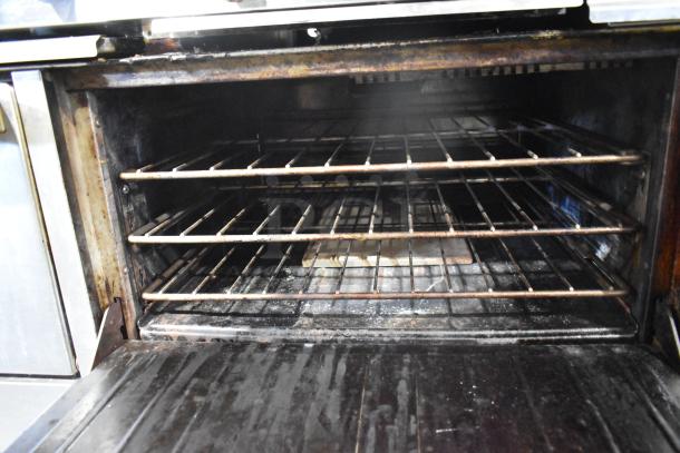 Garland commercial gas range oven interior with multiple shelves, showing signs of use and wear.