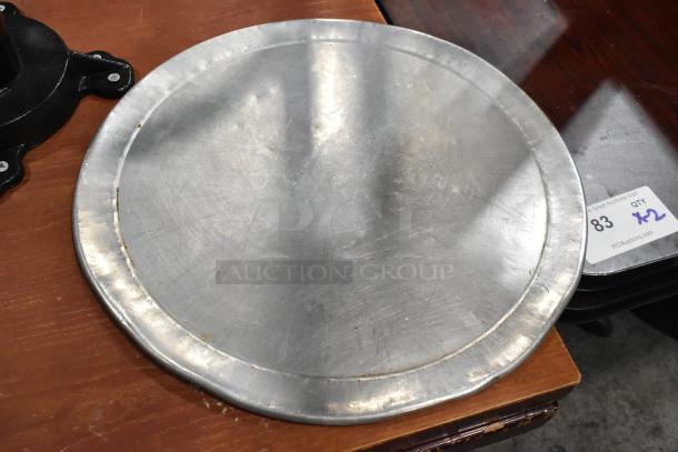 Round metal baking sheet with visible scratches, part of 51-item auction lot. Includes label indicating quantity.