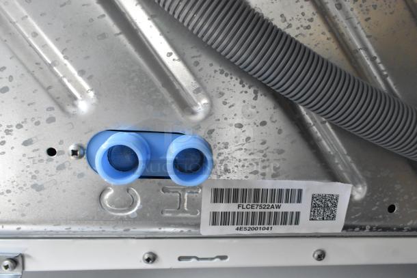 Brand new Frigidaire FLCE7522AW stacked washer/dryer, 2025 model, scratch/dent; visible labels with model and serial numbers.