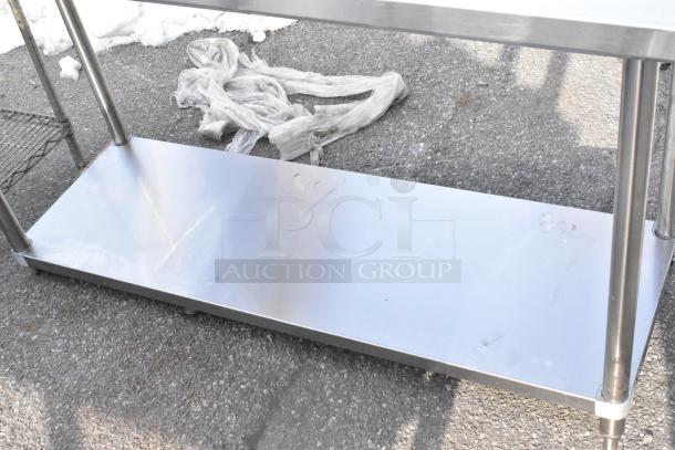 Regency 600TSB2460S stainless steel table with under shelf and backsplash, shown outdoors, in used condition.