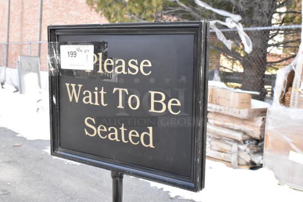 Black sign with white text "Please Wait To Be Seated," minor wear, auction tag marked "199" visible.