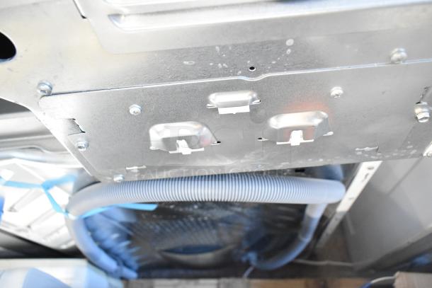 2025 Frigidaire FLCE7522AW stacked washer and dryer, scratch and dent condition, metal components visible from underside.