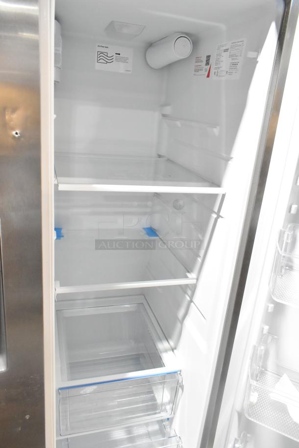 Brand new 2025 Frigidaire FRSS2623ASN fridge, French doors, drawer freezer, water/ice dispenser. Scratch and dent visible.