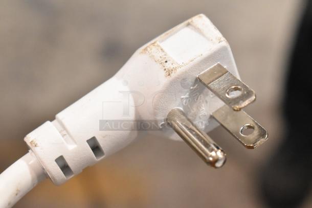 Close-up of Magic Chef HMCF5W4 chest freezer power plug, showing a standard three-prong design with slight dirt marks.