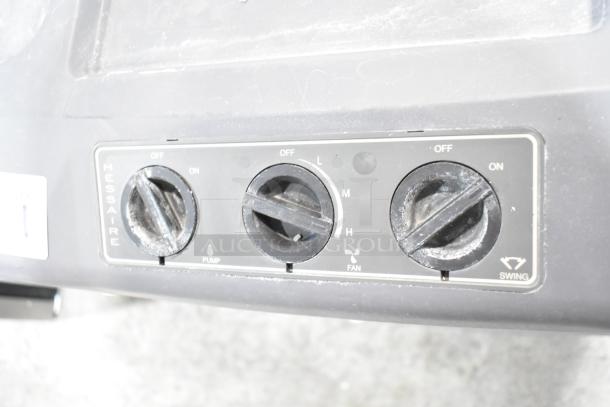 Control panel of Hessaire MC37V Mobile Evaporative Cooler showing pump, fan, and swing settings with visible wear.