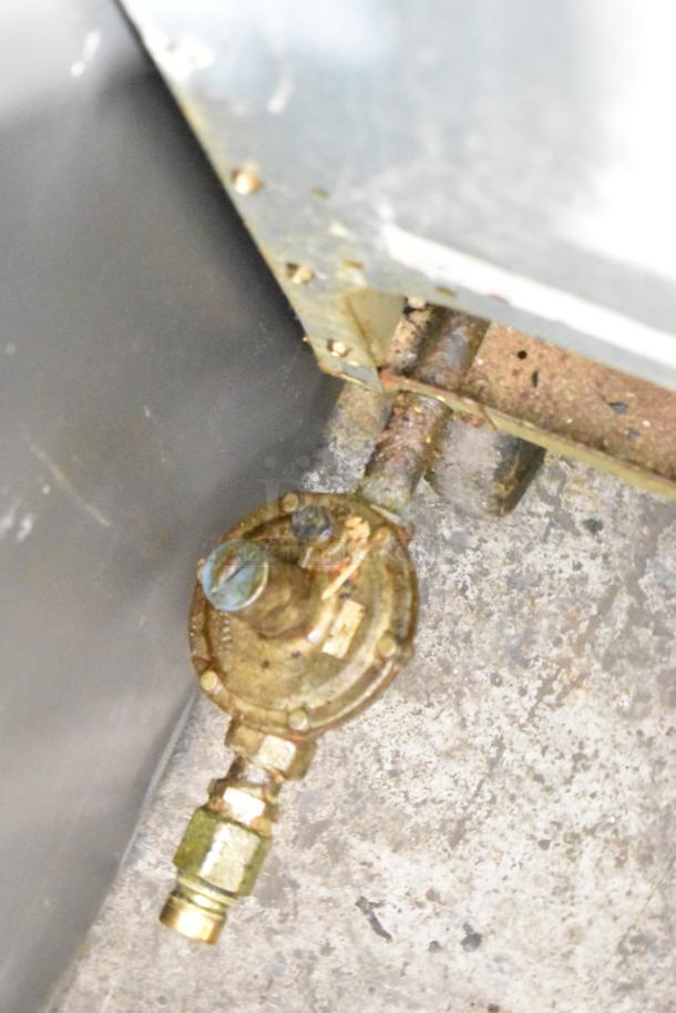 Close-up of a Frymaster GF40SD fryer gas connection, showing used condition and metal fittings. Model: GF40SD.