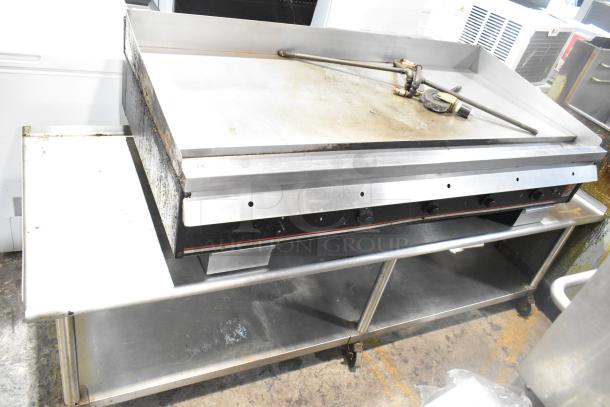 Wolf Regency commercial countertop flat top griddle with thermostatic controls, equipment stand, and commercial casters. Used condition.