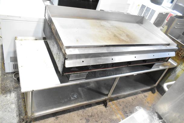 Wolf Regency commercial countertop flat top griddle with thermostatic controls on equipment stand with casters, lightly used.