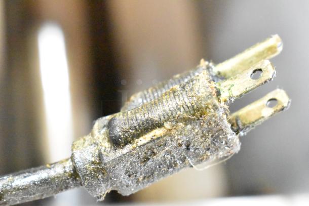 Close-up image of a worn plug from a Wolf Regency Commercial Griddle, showing dirt and signs of heavy use.