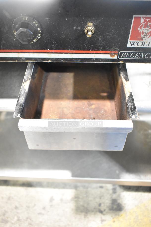 Wolf Regency countertop griddle with thermostatic controls, shown on equipment stand with commercial casters. Visible branding.