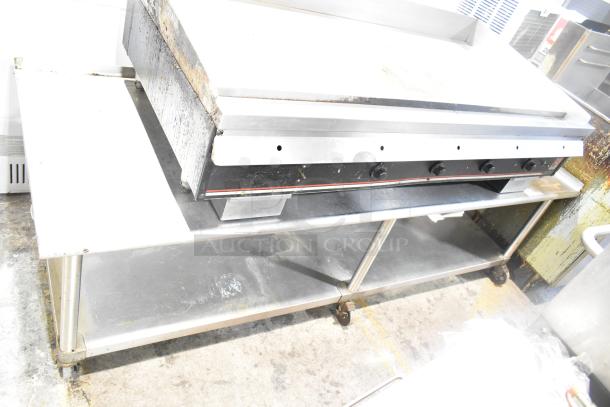 Wolf Regency Commercial Countertop Flat Top Griddle with thermostatic controls, stainless steel stand, and commercial casters.