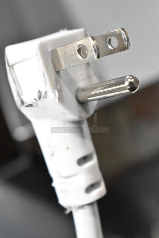 Close-up of a power plug for the 2025 Vissani HMCF7W5 chest freezer, showing prongs and a white cord, indicating proper condition.